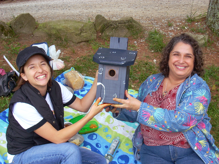 Jenny showing off the birdhouse she painted with her mom.